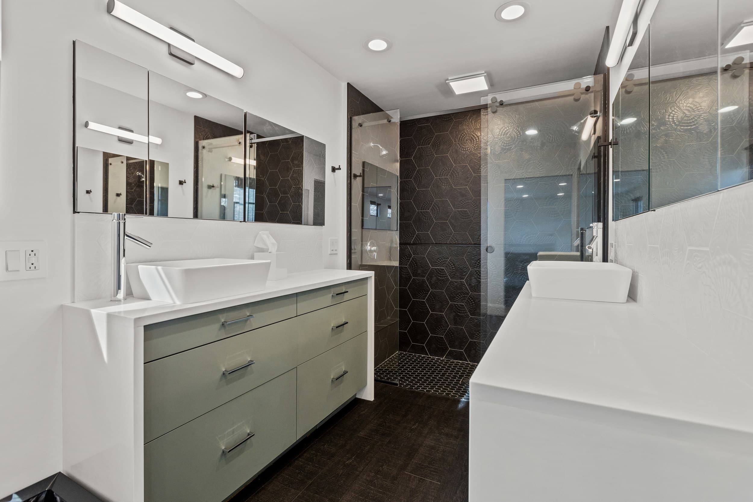 Green double vanity and black tile shower