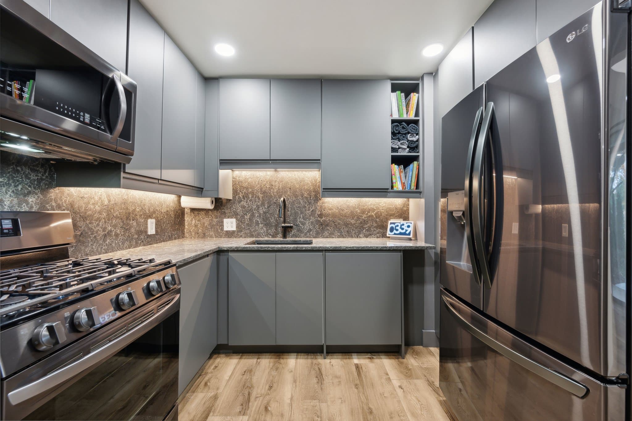 Gray kitchen with integrated handles and undercabinet lighting