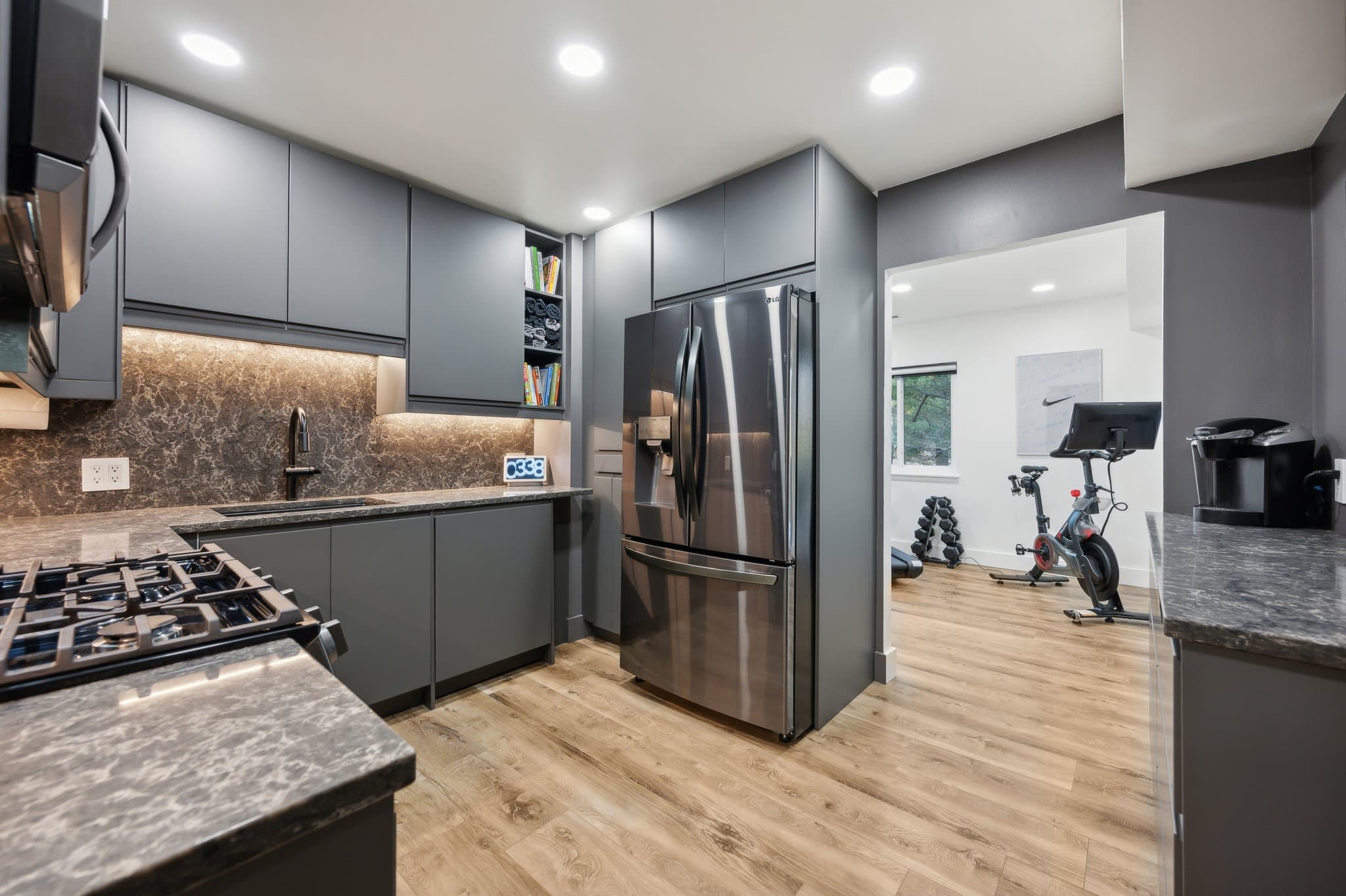 Gray kitchen with integrated handles and stainless refrigerator